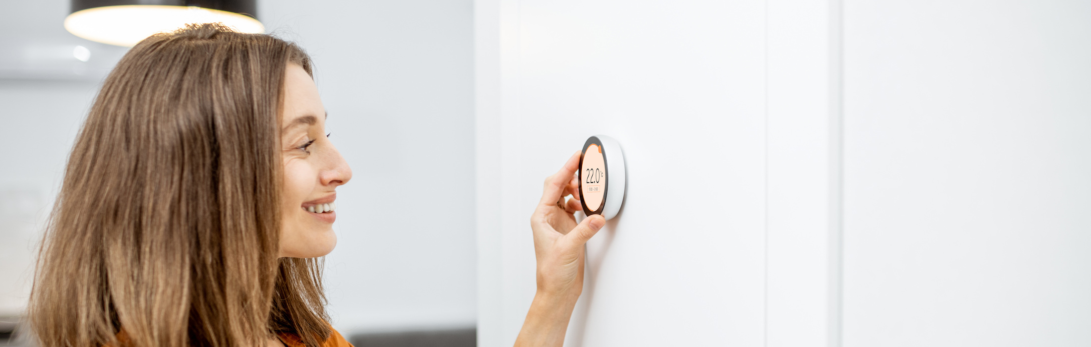 Young woman regulating heating temperature