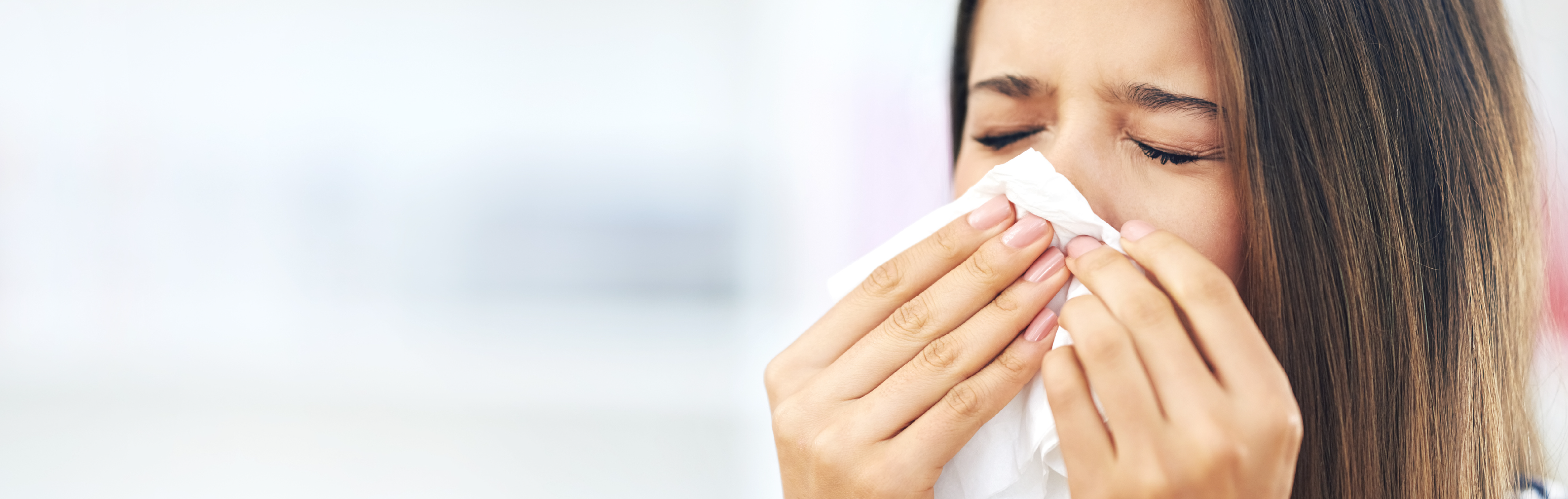 Woman using a tissue on her nose