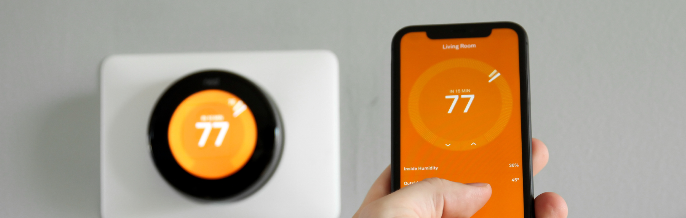 photo of a digital thermostat and mobile phone controlling thermostat - HVAC Solutions by Chancey & Reynolds