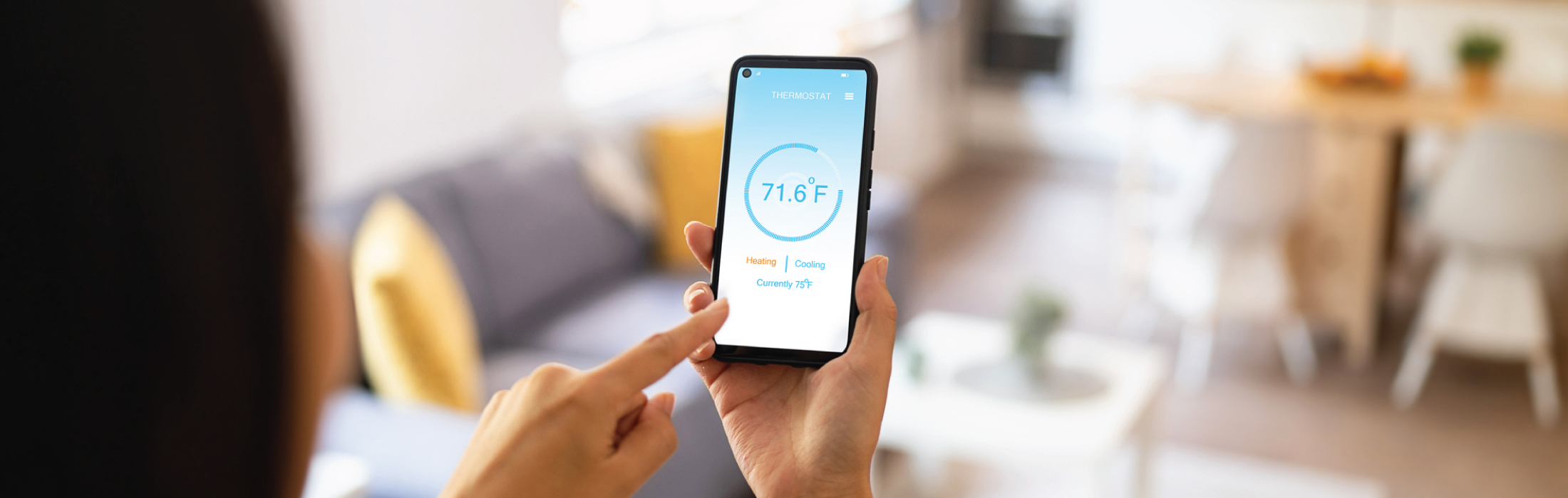 Photo of phone with HVAC smart app to keep cost down on energy